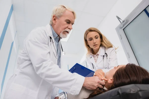 Foco Selectivo Los Médicos Con Portapapeles Comprobando Pulso Mujer Estiramiento — Foto de Stock