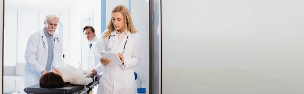 Horizontal Crop Doctor Using Digital Tablet Colleagues Patient Stretcher Clinic — Stock Photo, Image