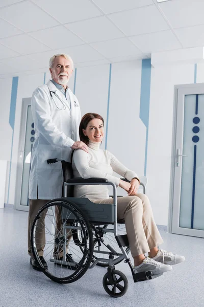 Mulher Morena Cadeira Rodas Olhando Para Câmera Perto Médico Clínica — Fotografia de Stock