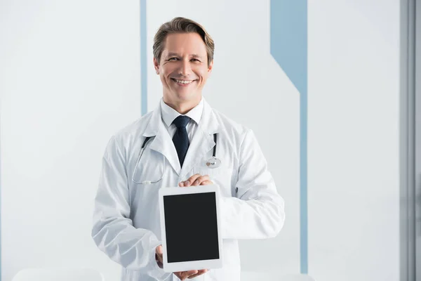 Beyaz Önlüklü Doktor Kameraya Bakıyor Hastanedeki Boş Ekranlı Dijital Tableti — Stok fotoğraf