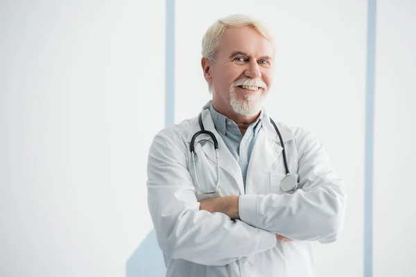 Médico Idoso Com Braços Cruzados Olhando Para Câmera — Fotografia de Stock