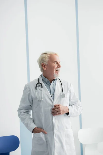 Γκριζομάλλης Γιατρός Κοιτάζει Αλλού Ενώ Δουλεύει Στο Νοσοκομείο — Φωτογραφία Αρχείου
