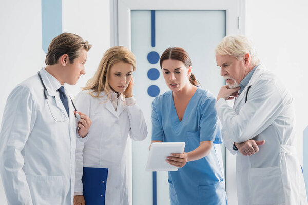 Медсестра показывает цифровые таблетки врачам в больнице 
