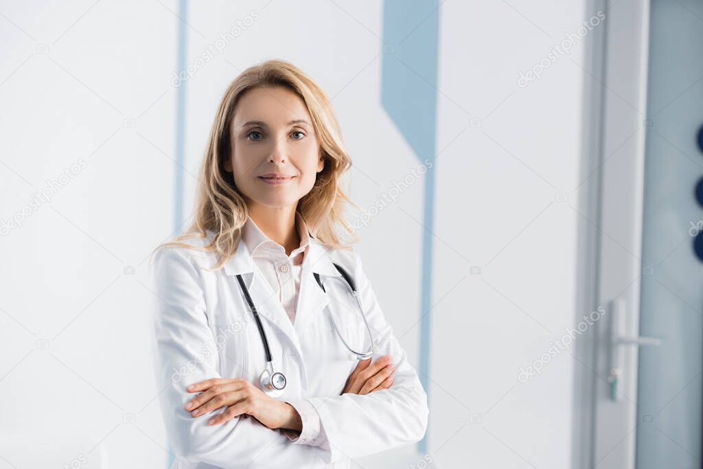 Blonde doctor with stethoscope looking at camera in clinic 