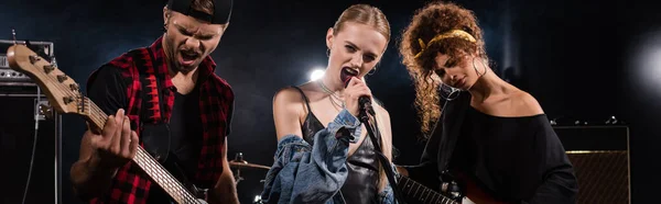 Vocalista Femenina Banda Rock Cantando Cerca Guitarristas Con Retroiluminación Fondo — Foto de Stock