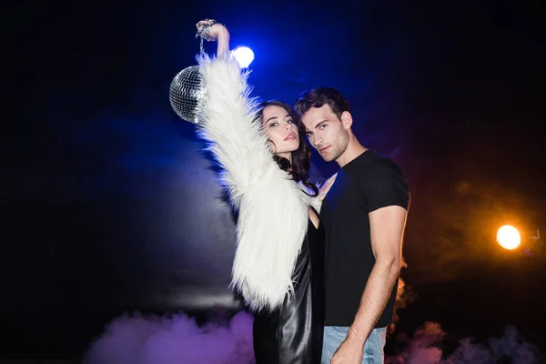 Brunette Woman Holding Disco Ball Air While Embracing Boyfriend Looking — Stock Photo, Image