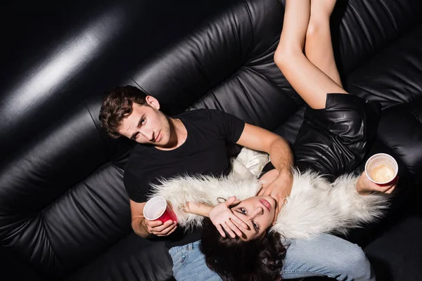 Confident Boyfriend Plastic Cup Touching Woman Neck Sitting Sofa Looking — Stock Photo, Image