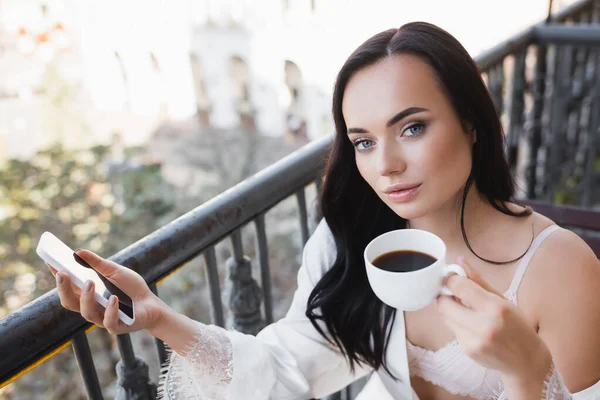 Beautiful Brunette Woman White Robe Drinking Coffee Balcony Holding Smartphone — Stock Photo, Image