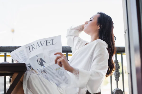 Μελαχρινή Γυναίκα Λευκό Ρόμπα Κάθεται Στο Μπαλκόνι Και Διαβάζοντας Εφημερίδα — Φωτογραφία Αρχείου