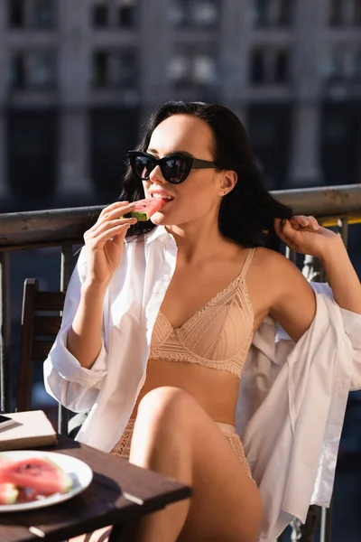 穿着米色内裤的性感女人在阳台上吃西瓜 — 图库照片