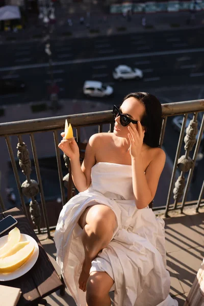 Sexy Brunette Woman Sunglasses Covered White Sheet Eating Melon Balcony — Stock Photo, Image