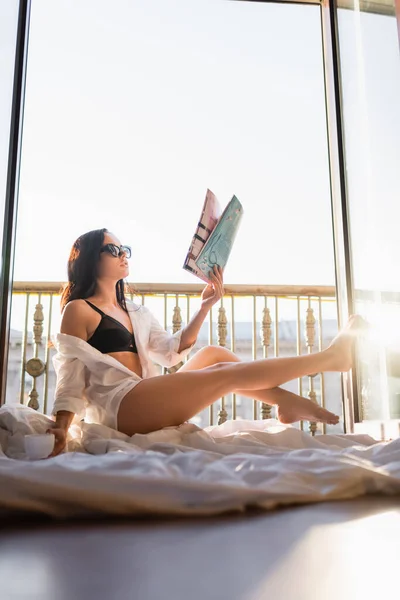 Όμορφη Μελαχρινή Γυναίκα Γυαλιά Ηλίου Και Μαύρο Εσώρουχα Ανάγνωση Περιοδικό — Φωτογραφία Αρχείου