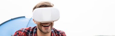 Yüzü bulanık arka planı olan vr kulaklık kullanan gülümseyen adam beyaz pankartta izole edilmiş. 