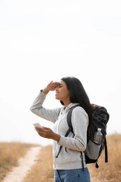 Smiling African American Hiker Smartphone Backpack Looking Away Path Blurred — Stock Photo, Image