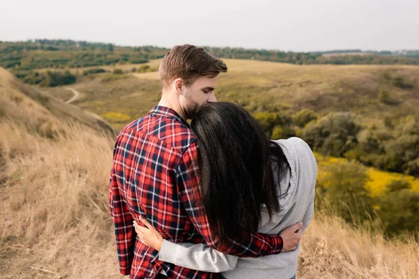 Back View Young Man Hugging African American Girlfriend Grassy Hills — Stock Photo, Image