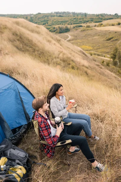 High Angle View Smiling Multiethnic Tourists Cup Thermos Sitting Backpacks — Stock Photo, Image