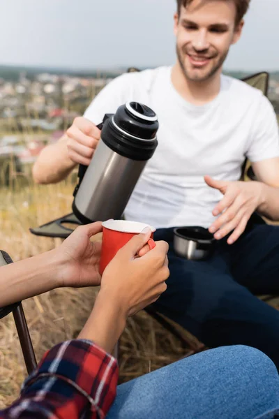 Mujer Afroamericana Sosteniendo Taza Cerca Hombre Sonriente Con Termos Primer — Foto de Stock