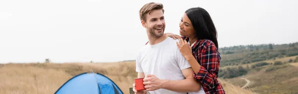 African American Woman Smiling Hugging Boyfriend Cup Tent Blurred Background — Stock Photo, Image