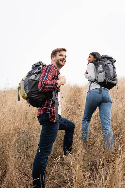 Glimlachende Man Houden Rugzak Terwijl Staan Buurt Van Afrikaans Amerikaanse — Stockfoto