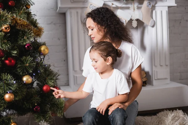 Moeder Dochter Aanraken Kerstbal Feestelijke Dennen Buurt Van Open Haard — Stockfoto