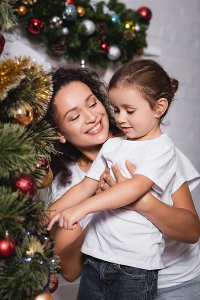 Moeder Knuffelen Dochter Buurt Feestelijke Pijnboom Thuis — Stockfoto