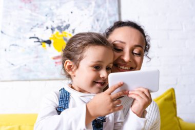 Arka planda resmi olan cep telefonlu anne ve kızın seçmeli odak noktası