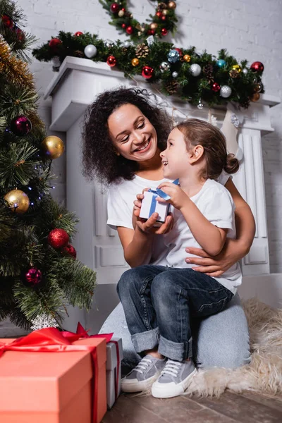 Mother Embracing Daughter Gift Box Decorated Pine Fireplace Home — Stock Photo, Image