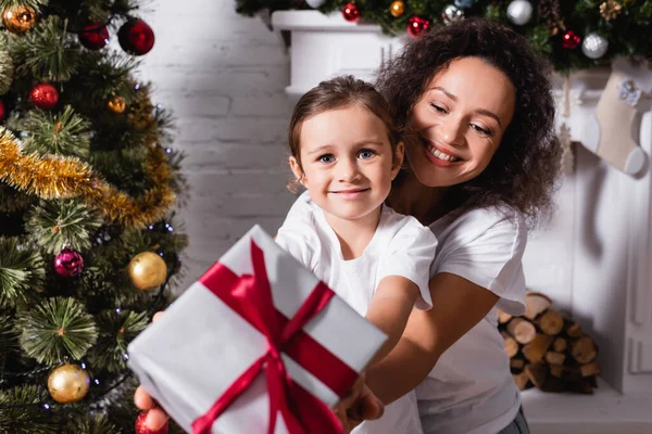 Mutter Mit Tochter Zeigt Geschenkbox Und Blickt Die Kamera Kamin — Stockfoto