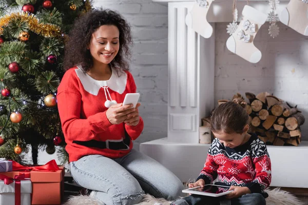 Mother Daughter Using Gadgets Sitting Pine Fireplace Home — Stock Photo, Image