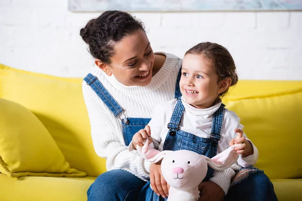 Mãe Sentada Sofá Abraçando Filha Com Brinquedo Macio Casa — Fotografia de Stock