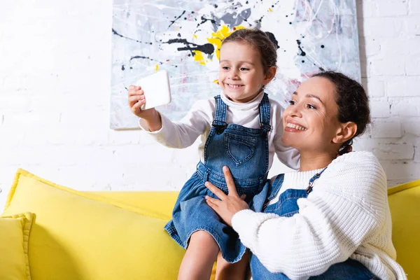 Matka Córka Robiące Selfie Żółtej Kanapie Zdjęciem Tle — Zdjęcie stockowe