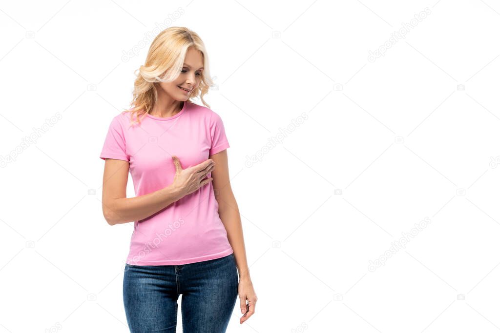 Blonde woman in pink t-shirt touching breast isolated on white, concept of breast cancer awareness