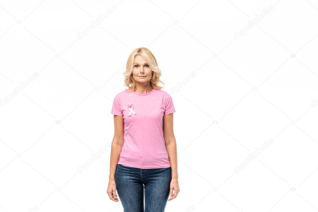 Blonde woman with pink ribbon of breast cancer awareness looking at camera isolated on white
