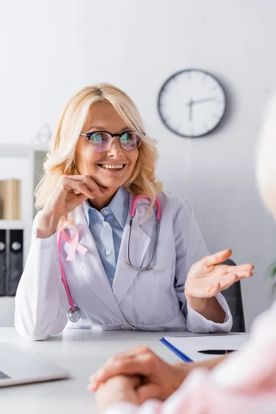Selective Focus Doctor Pink Ribbon Looking Away While Sitting Table — Stock Photo, Image