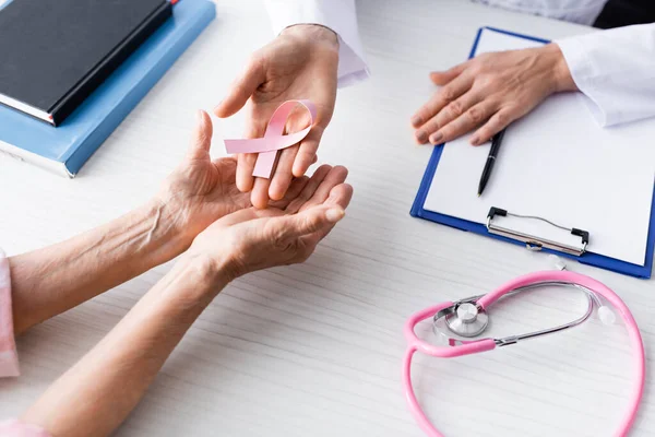 Cropped View Doctor Patient Holding Pink Ribbon Hands Workplace — Stock Photo, Image