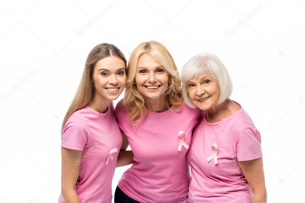 Women with ribbons of breast cancer awareness embracing and looking at camera isolated on white