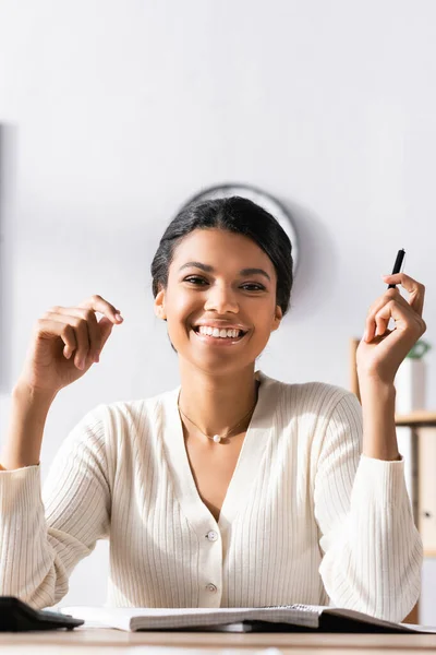 Glückliche Afrikanisch Amerikanische Geschäftsfrau Mit Stift Blickt Die Kamera Während — Stockfoto