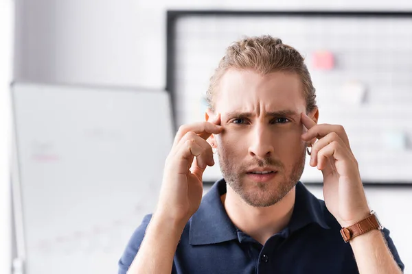 Exhausted Office Worker Looking Camera While Touching Head Hands Workplace — Stock Photo, Image