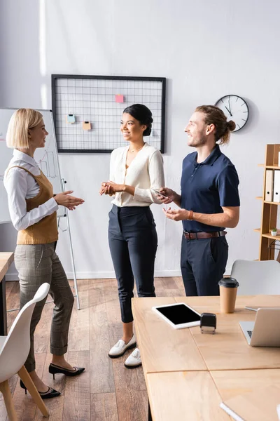 Para Pekerja Kantor Yang Multikultural Tersenyum Sambil Berdiri Dekat Tempat — Stok Foto