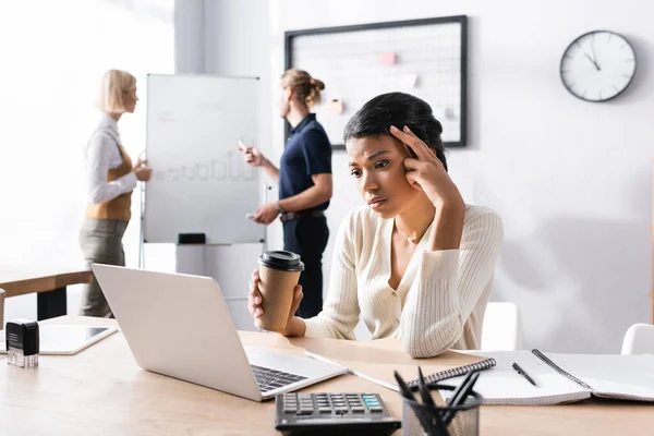 Trött Afrikansk Amerikansk Kvinna Med Papper Kopp Tittar Laptop Arbetsplatsen — Stockfoto