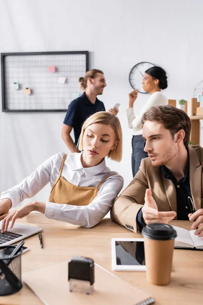 Gericht Blonde Vrouw Typen Laptop Tijdens Het Luisteren Man Zit — Stockfoto