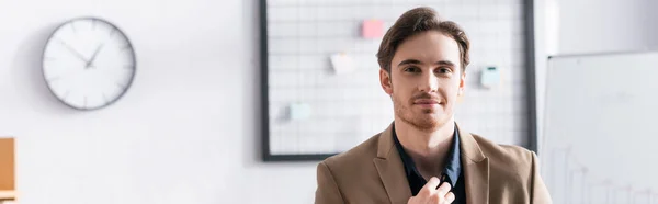 Hombre Negocios Positivo Mirando Cámara Mientras Toca Cuello Camisa Oficina — Foto de Stock