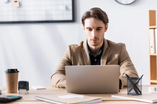 Fokuserad Kontorsarbetare Tittar Bärbar Dator Medan Sitter Vid Skrivbordet Med — Stockfoto