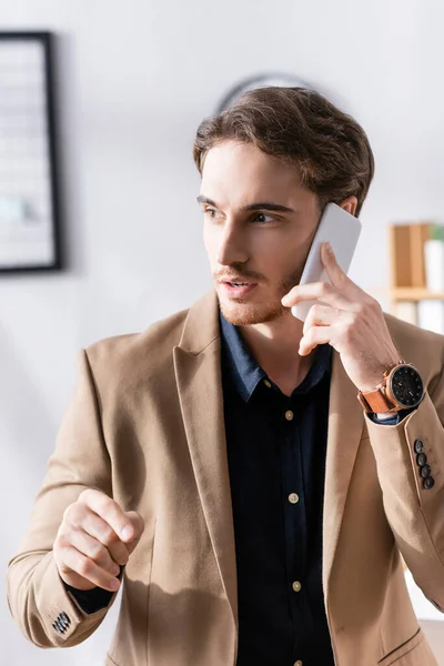 Empresário Confiante Gesticulando Olhando Para Longe Enquanto Fala Telefone Celular — Fotografia de Stock