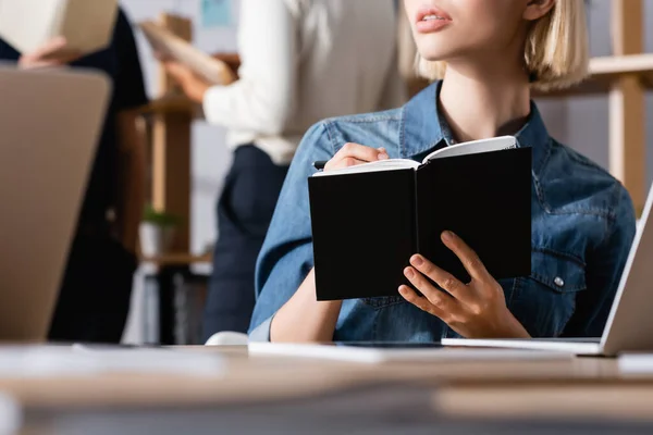 Cropped View Blonde Woman Writing Notebook While Sitting Laptop Blurred — Stock Photo, Image