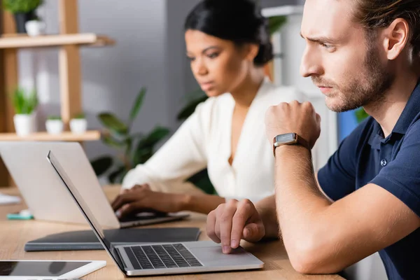 Konzentrierte Büroangestellte Mit Uhr Und Laptop Während Sie Arbeitsplatz Mit — Stockfoto