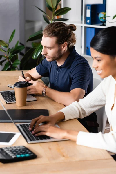 Hombre Enfocado Escribiendo Cuaderno Mientras Está Sentado Lugar Trabajo Cerca — Foto de Stock