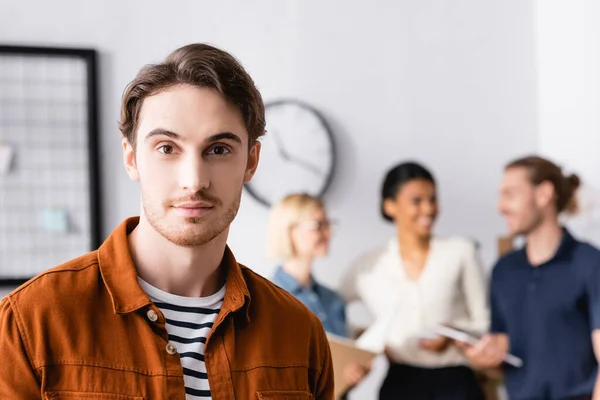 Jonge Manager Kijken Naar Camera Terwijl Multi Etnische Zakenmensen Bespreken — Stockfoto