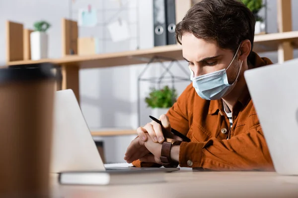 Young Manager Medical Mask Looking Wristwatch Blurred Foreground — Stock Photo, Image