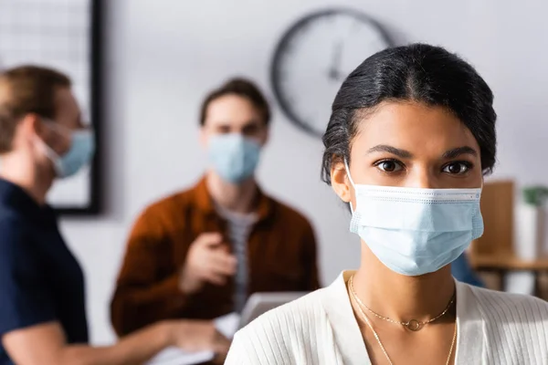 African American Businesswoman Protective Mask Looking Camera Managers Blurred Background — Stock Photo, Image